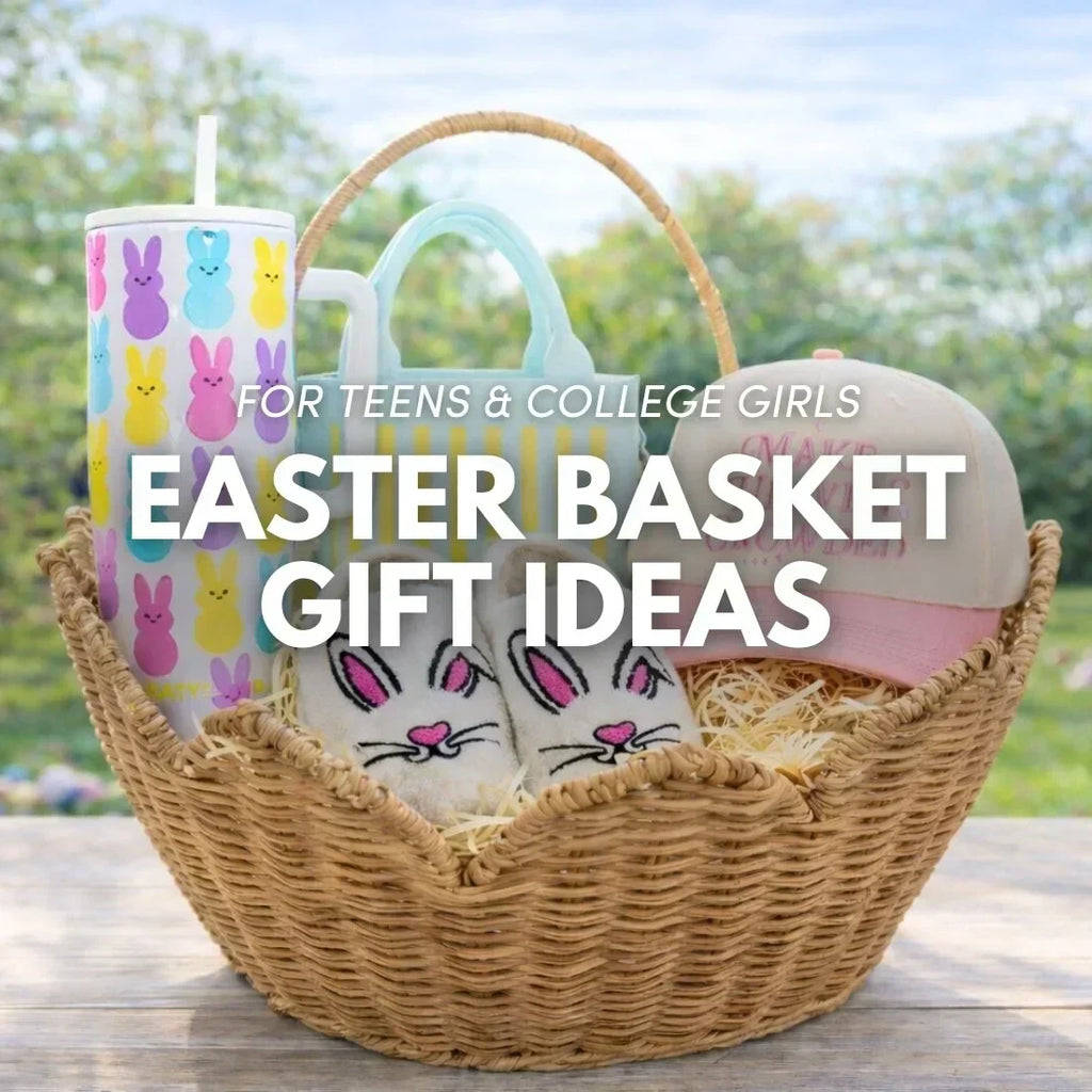 Easter basket gift ideas for teens and college girls featuring a bunny print tumbler, striped mini tote bag, bunny slippers, and a pink trucker hat in a rattan basket outdoors.
