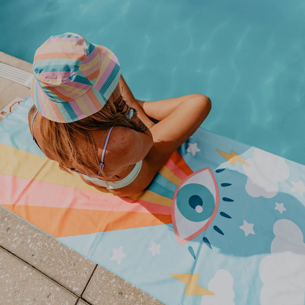 woman sitting on a beach towel by the pool