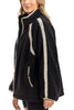 A woman stands in profile, smiling slightly, wearing the Katydid Black Sherpa Lace Trim Jacket featuring cozy fabric and cream crochet detailing on the shoulders, arms, and pockets.