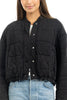 A person models the Katydid Black Cropped Quilted Bomber Jacket with snap buttons over a white top and light blue jeans, shown from shoulders to waist against a white background that highlights this classic fall style.
