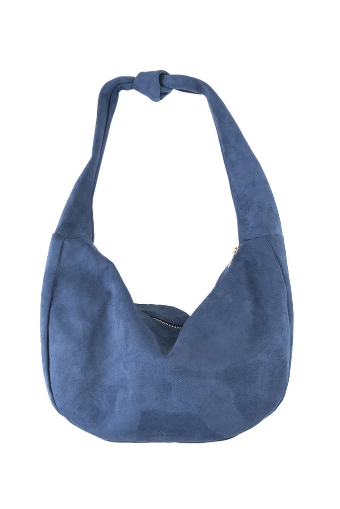 The Katydid Blue Suede Evening Tote is a roomy, slouchy bag with a rounded shape, knotted strap, and top zipper closure.