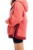 A woman models the Katydid Coral Two-Toned Womens Fleece Pullover, featuring maroon trim, paired with black shorts. She stands sideways, and only her upper body is visible.