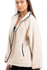 A woman wearing the Katydid Cream Womens Sherpa Lace Trim Jacket stands sideways, smiling slightly. This cozy fall jacket features a soft texture, relaxed fit, and lace trim—perfect for chilly days.