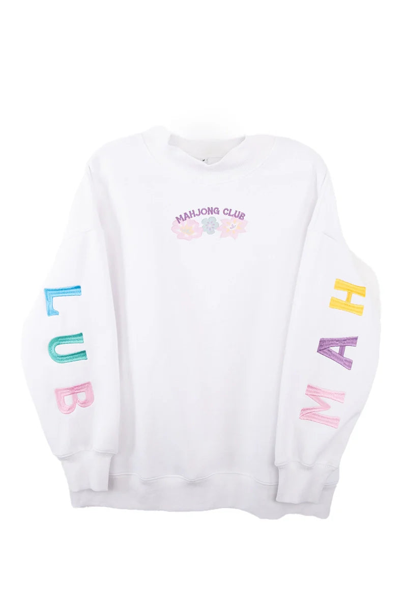 The Katydid Mahjong Club Mockneck Pullover features pastel flower graphics and MAHJONG CLUB on the chest, colorful CLUB on the left sleeve, and MAHJ on the right—ideal for cozy game nights or your new favorite sweatshirt.