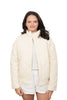 A woman with dark hair wears the Katydid Cloud White Sporty Diamond Quilted Jacket over a white shirt and white shorts, standing against a plain white background.