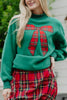 A woman wears the Katydid Red Plaid Bow Mockneck Sweatshirt, styled with a matching red plaid skirt for a festive holiday look as she stands outdoors.