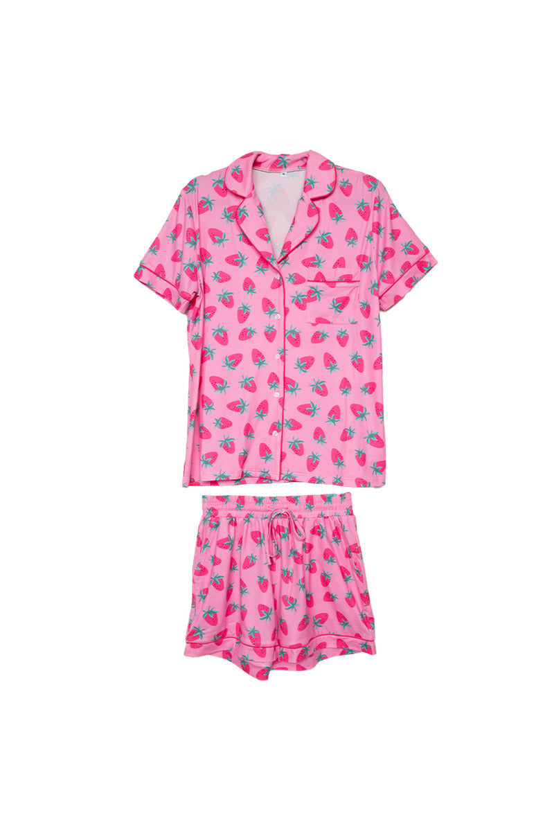 The Katydid Pink Strawberry Print PJ Loungewear Set is a women’s pajama set with a button-up top, matching shorts, dark pink piping, and a fun strawberry print.