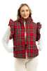 A woman smiles at the camera, hands in pockets, wearing the Katydid Royal Stewart Plaid Ruffle Puffer Vest over a white long-sleeve top and light pants—an ideal cheerful holiday look against a white background.