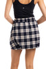 A person wearing a black tank top and the Katydid Blue Autumn Plaid Skirt, shown from the back with arms bent and hands behind their back.