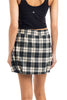 A person wearing a black sleeveless top and a Katydid Green Autumn Plaid Skort, shown from the back.
