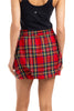 A person shown from the back wears a black sleeveless top and a Katydid Royal Stewart Plaid Mini Bubble Skirt, featuring red fabric with yellow, green, and blue stripes.