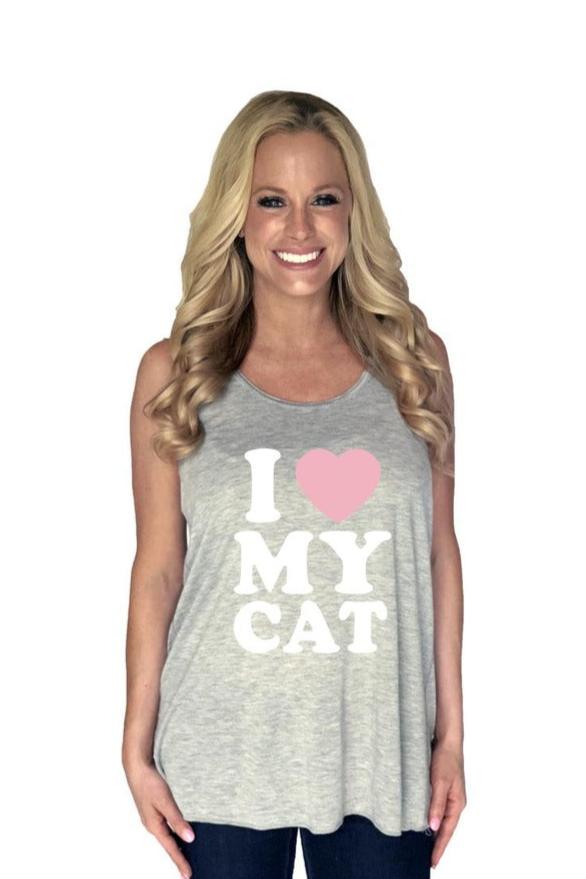 A smiling woman with long blonde hair wears a Katydid I Love My Cat tank top featuring a pink heart, posing against a plain white background.