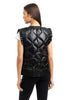 A woman with straight brown hair is seen from the back wearing the Katydid Black Metallic Quilted Vest over a white shirt and black pants, showcasing stylish womens outerwear against a plain white background.