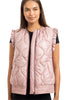 A woman smiles with her hair down, wearing the Katydid Blush Metallic Puffy Vest over a black short-sleeve top for a fresh, feminine look.