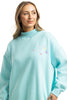 A woman with long blonde hair models the Katydid Make Heaven Crowded Womens Mockneck Top, featuring MAKE THE DAY GROOVY and colorful embroidered flowers, against a white background.