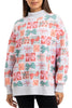 A woman stands with her hands at her sides, wearing the Katydid Wrapped Presents with Bows mockneck pullover—a holiday sweatshirt featuring a colorful pattern of gift boxes and bows in red, pink, green, and white.
