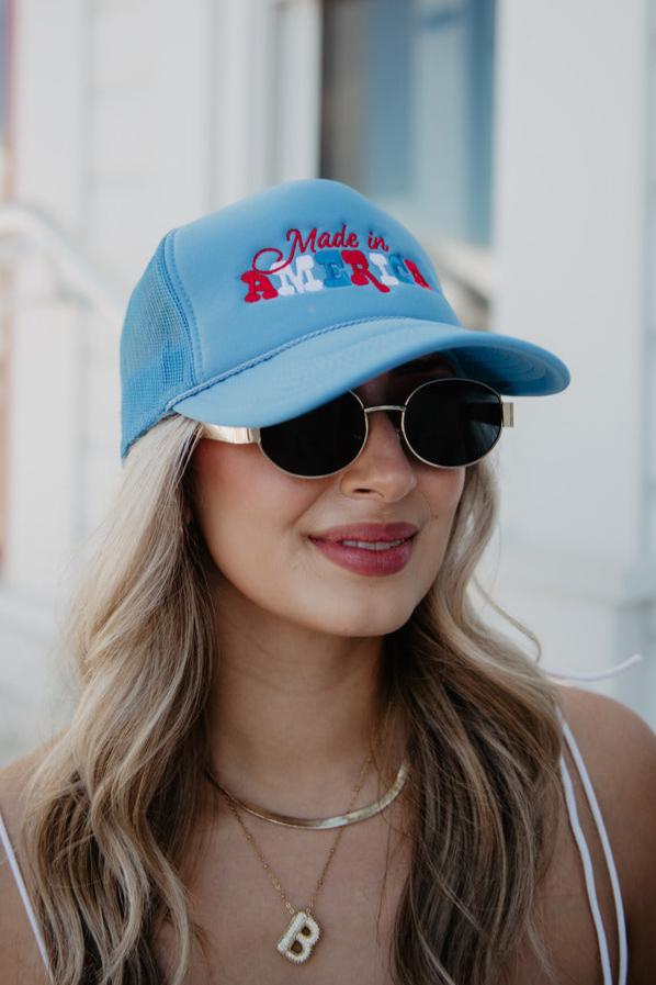 A woman wearing a red white and blue made in america hat and sunglasses