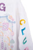 A close-up of the Katydid Mahjong Club Mockneck Pullover, a white sweatshirt with colorful G, C, E, and A letters on the sleeve and pastel floral and decorative patterns on the fabric.