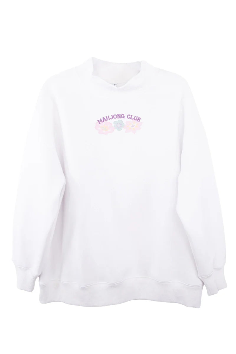 The Katydid Mahjong Club Mockneck Pullover is a white sweatshirt with “MAHJONG CLUB” in pink plus pastel mahjong tiles and flowers on the chest—perfect for girls’ game night.