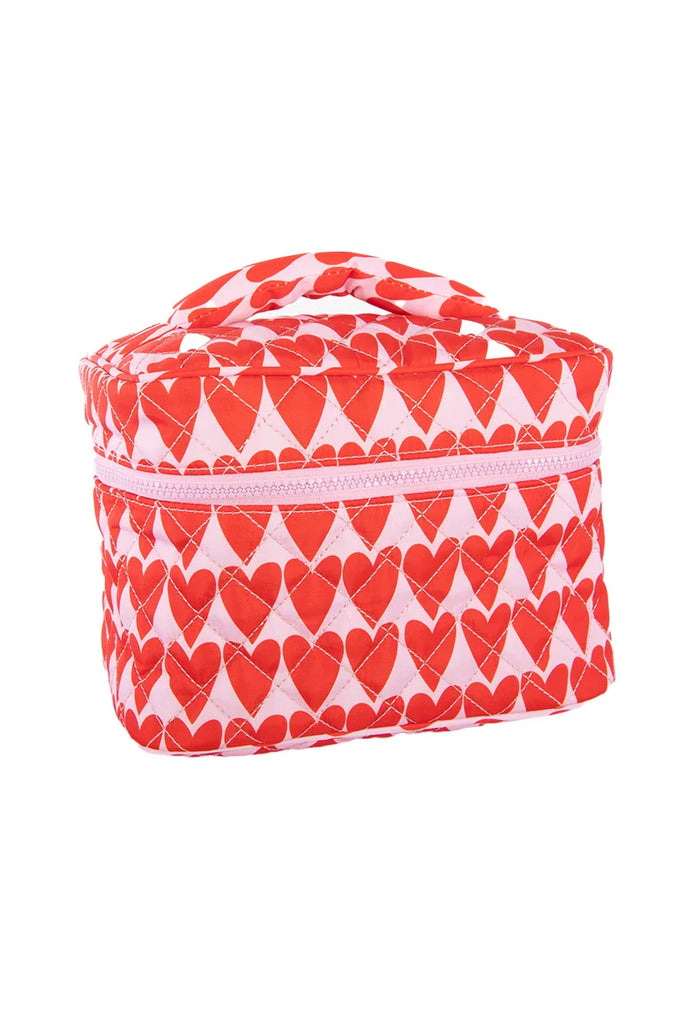 The Katydid Girly Red Hearts Makeup Bag features a quilted white design with red hearts, a zipper closure, and a handy top handle for easy carrying.