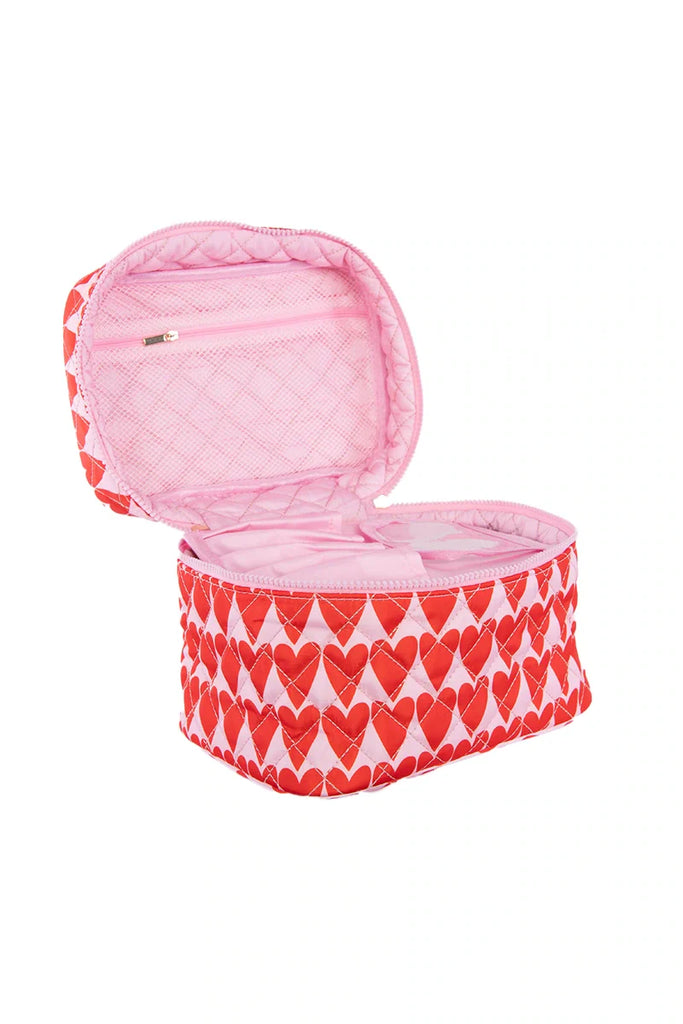 The Katydid Girly Red Hearts Makeup Bag features pink quilted fabric with red hearts, an open lid with a zippered pocket, and a roomy main compartment—ideal for organizing your beauty essentials.