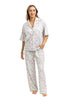 A woman models the Katydid Mahjong Pieces Pajama Pants Set: a light-colored, short-sleeve button-up shirt with matching long pants, featuring a playful print—ideal for fans of girly pajamas.
