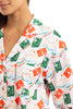 A woman wears Katydids Santas Mail Christmas Pajamas for Women—a button-up shirt with green and red postage stamps, dolphins, sunglasses, and starfish on white—perfect to pair with holiday pajama pants. Only her lower face is shown.
