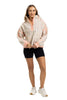 A woman with long hair smiles in a Katydid Confetti Print Womens Pullover with peach accents, paired with black shorts and white sneakers, posing against a white background.