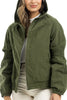 A woman poses with one hand in her pocket, wearing the Katydid Olive Lightweight Fall Jacket Women over a white top and light pants. This casual jacket offers gathered sleeve detailing and a relaxed fit.