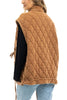 A woman with long hair is seen from the back wearing the Katydid Brown Oversized Womens Quilted Vest over a black top and light blue jeans, with one hand in her pocket.