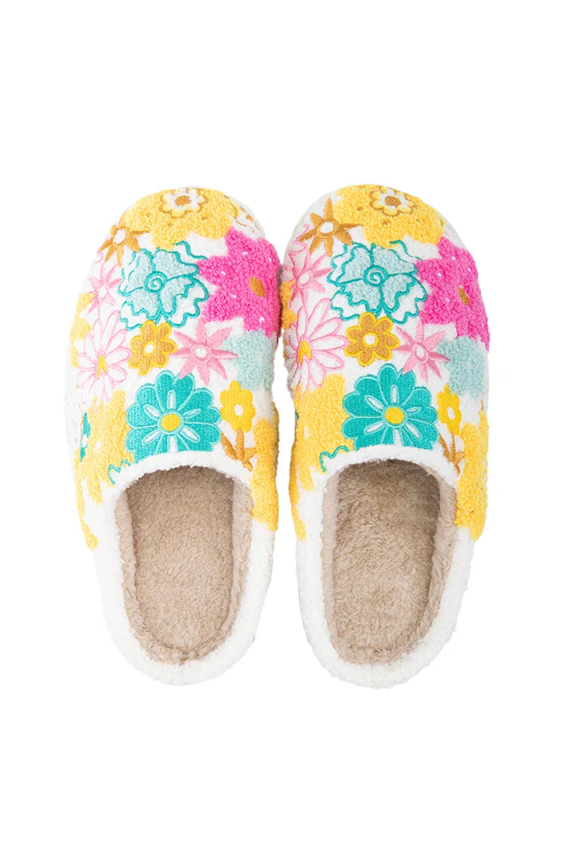 The Katydid Spring Flowers House Slippers for Women feature a cozy white base, beige fuzzy lining, and colorful embroidered flowers in yellow, teal, pink, and blue.