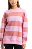 A person models the Katydid Pink and Light Pink Striped Mockneck Pullover, featuring wide horizontal stripes and long sleeves, with their arms relaxed at their sides against a white background. Only their upper body is visible.