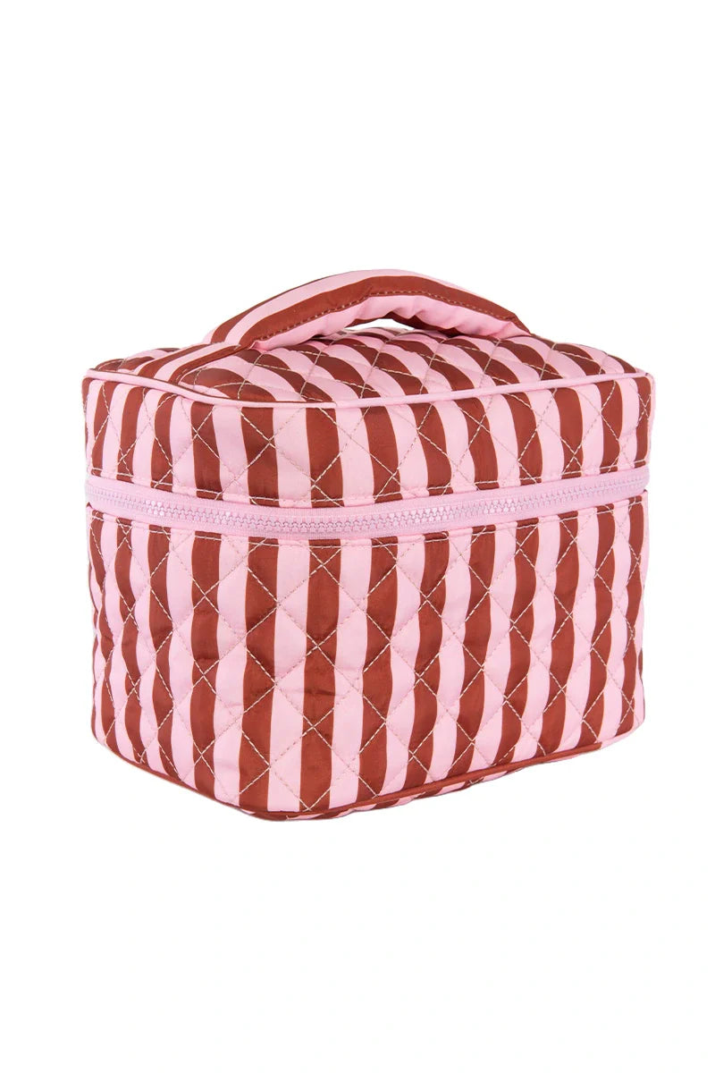 The Katydid Pink and Wine Striped Quilted Makeup Bag features diagonal pink and wine stripes, a handle, a rectangular shape, and a pink zipper around the top.