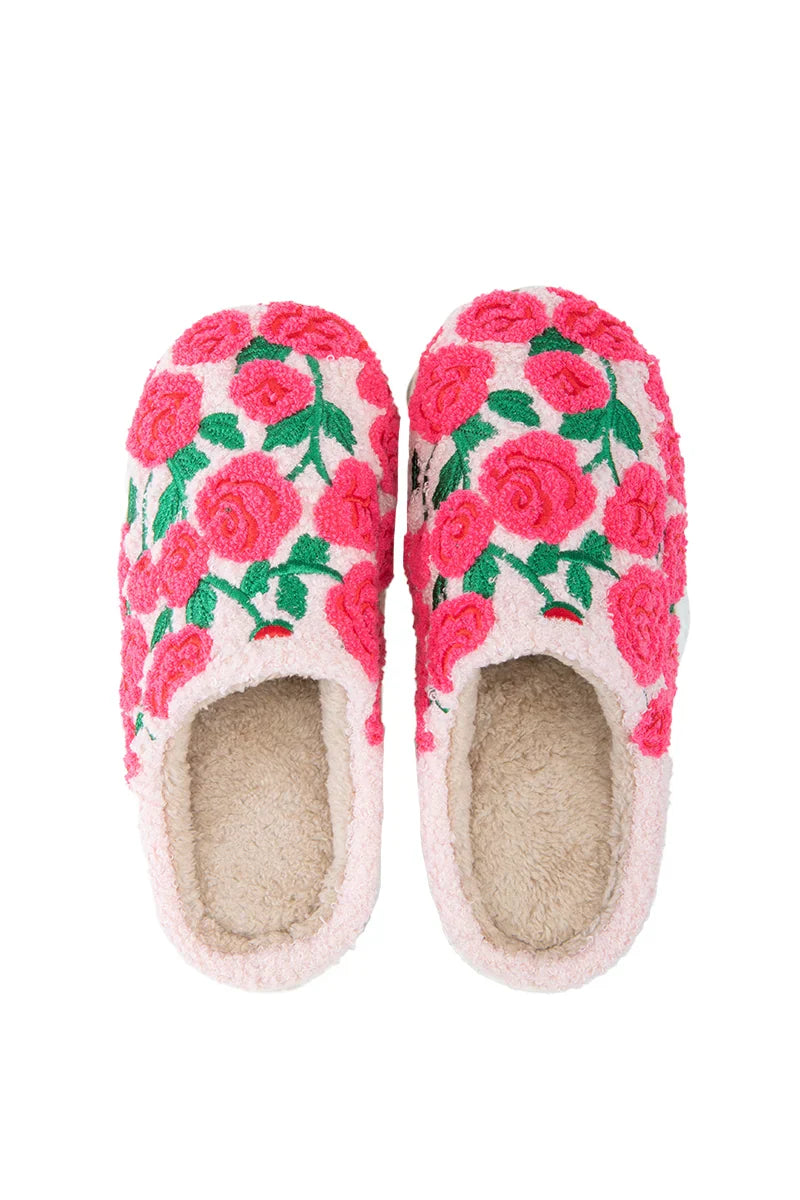 The Katydid Whimsical Roses Fuzzy Slippers for women feature a cream base with bright pink and red embroidered roses plus green leaves, shown from above against a white background.