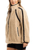 A person wears the Katydid Tan Sherpa Lace Trim Jacket, featuring textured sherpa with black lace trim—an ideal cozy layer for chilly fall days.