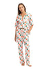 A woman wears Katydid’s Santas Mail Christmas Pajamas for Women, standing barefoot with red and green gift boxes—festive holiday sleepwear perfect for the season.
