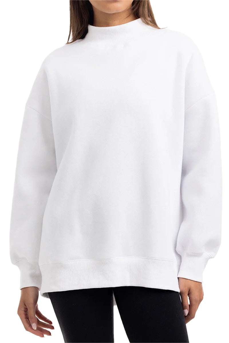 A person is shown from mid-thigh up, facing forward, wearing the Katydid Cloud White Essential Mockneck Sweatshirt with long sleeves and black pants; their face is not visible.