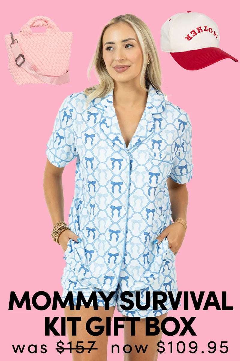 A woman in blue-and-white pajamas stands with hands in pockets. Above her: a pink quilted bag and a white-and-red “Mother” cap. Text: “Katydid.com Mommy Survival Kit Gift Box—was 157, now 109.95.” Perfect for Mother’s Day.
