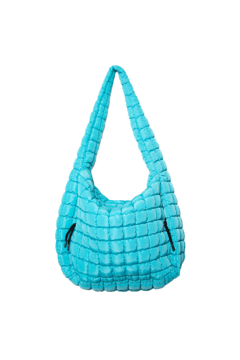 The Katydid Blue Quilted Womens Tote Bag features a bright turquoise-blue color, puffy texture, and black zipper details, shown against a plain white background.