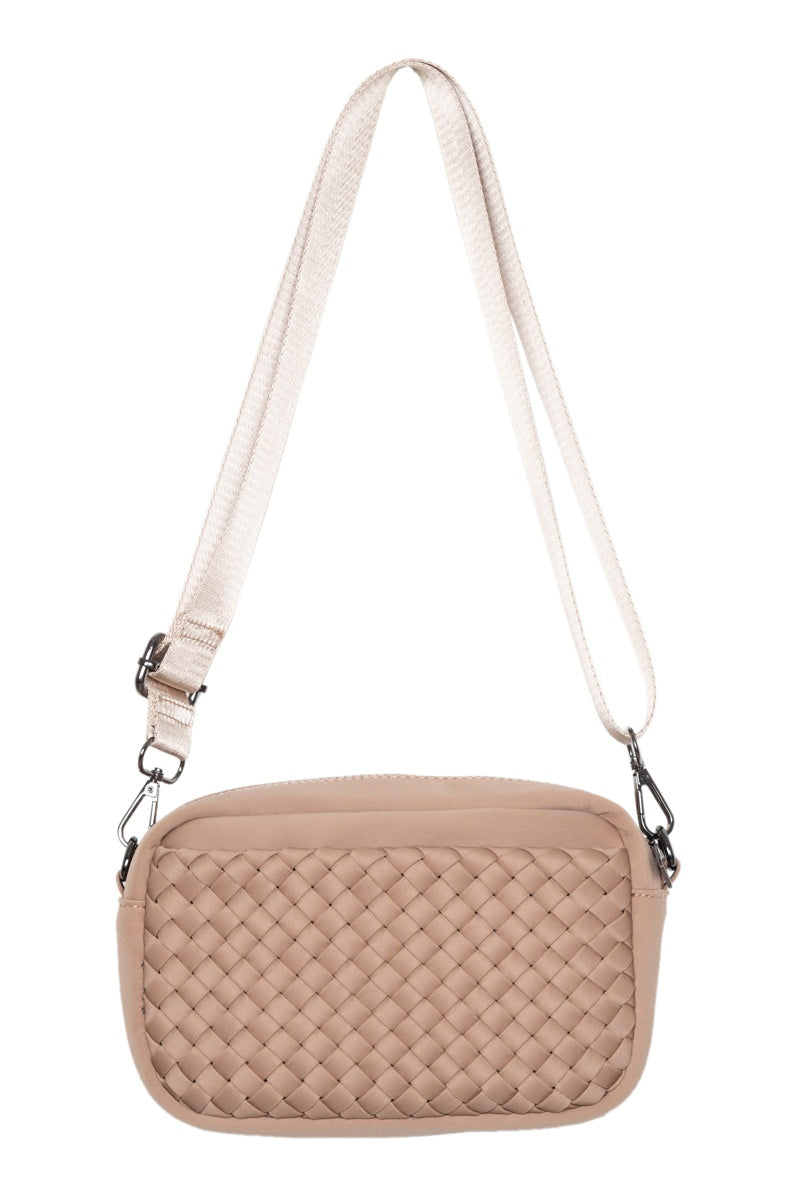 The Katydid Brown Woven Crossbody Bag is a women’s accessory with a rectangular shape, woven front texture, and an adjustable strap with metal clasps.