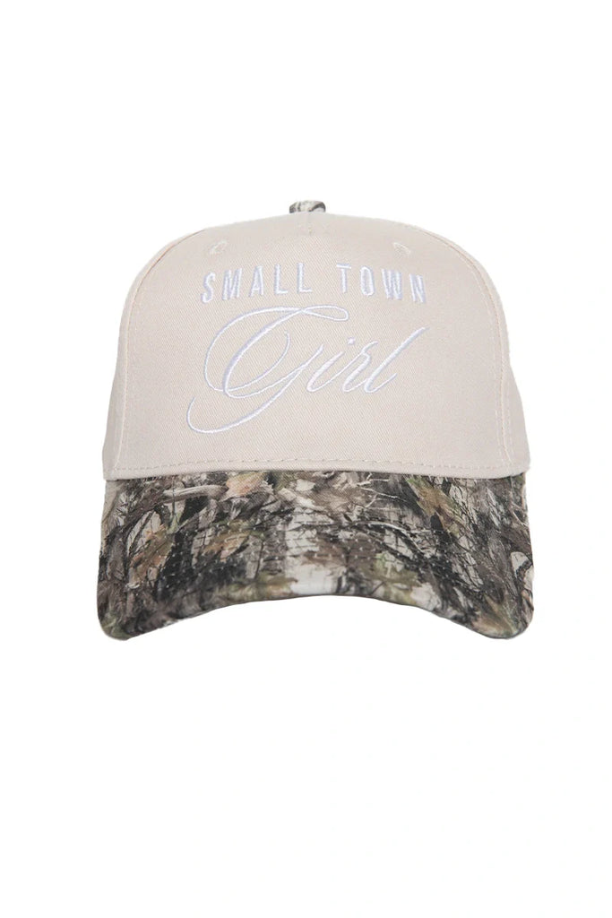 The Katydid Small Town Girl Vintage Trucker Hat for women features beige fabric, white front embroidery, and a camo-print brim—a charming country-cute cap ideal for relaxed days.