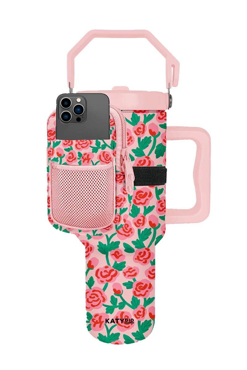 The Katydid Whimsical Roses Tumbler Zipper Pouch features an insulated cup holder with handle, pink floral pattern, smartphone pocket, and front mesh pouch—a stylish and functional tumbler accessory.