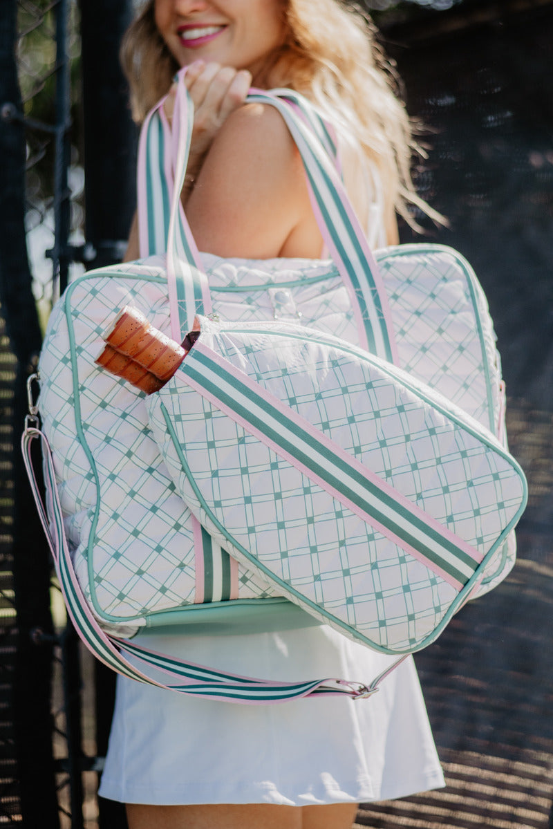 A woman carrying a white pickleball bag on her shoulder