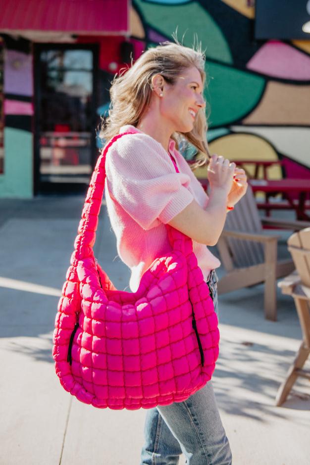 A hot pink quilted puffer tote bag