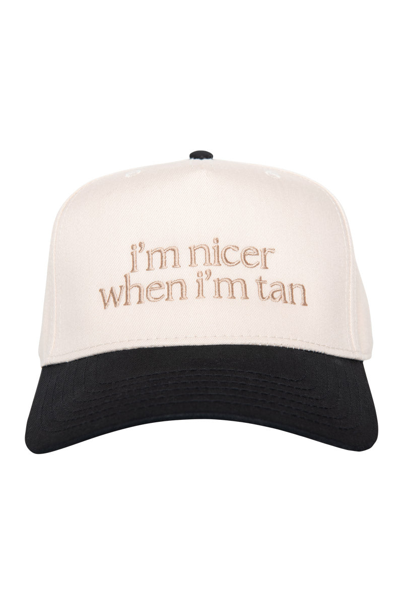 A white and black baseball cap featuring the embroidered text im nicer when im tan in beige thread on the front panel, ideal for styling with your favorite cozy slippers or adding to your Build Your Own Katydid Set 10 items for 60, a 350 value from Katydid.com for a personalized collection of cute accessories.