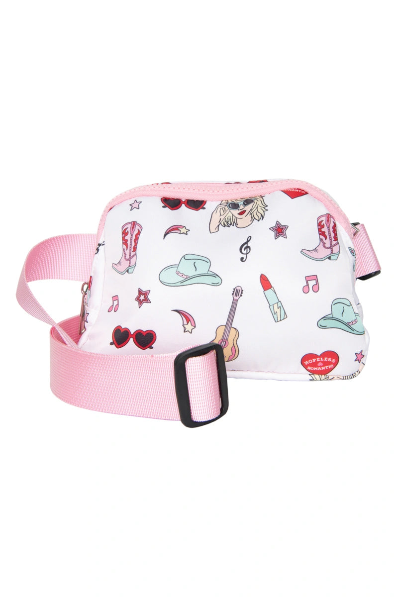 The Katydid Music Girl Icons Belt Bag is a small white crossbody with a pink adjustable strap, featuring playful icons like cowboy hats, boots, sunglasses, guitars, lipstick, hearts, and musical notes.