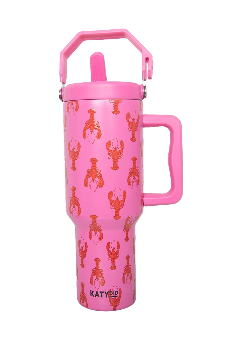 The Lobsters Tumbler Cup by Katydid is a tall, pink insulated travel mug with a large handle, flip-top lid, and an orange lobster print pattern plus the Katydid logo near the base.