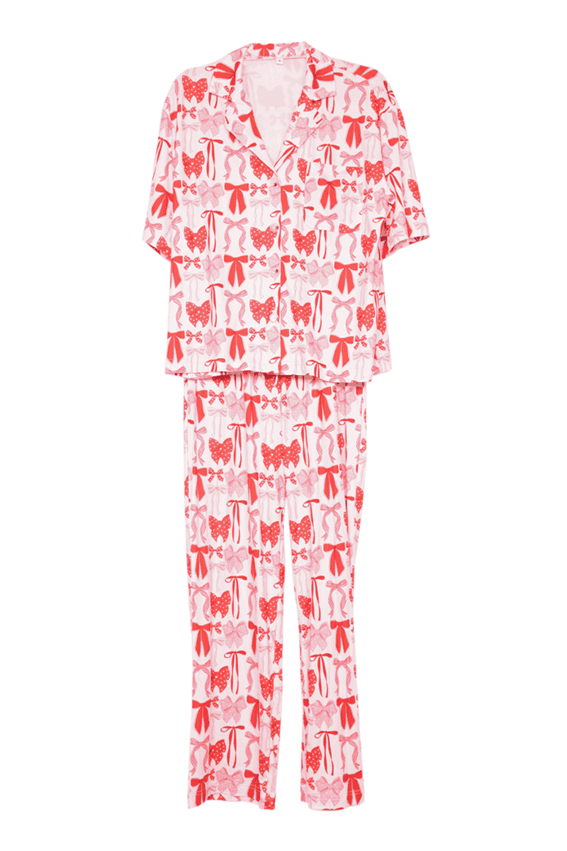 The Katydid Pink  Red Coquette Bows Womens Pajama Pants Set features a collared short-sleeve top and long pants with festive red and pink bow prints—ideal for Christmas pajamas or holiday loungewear.