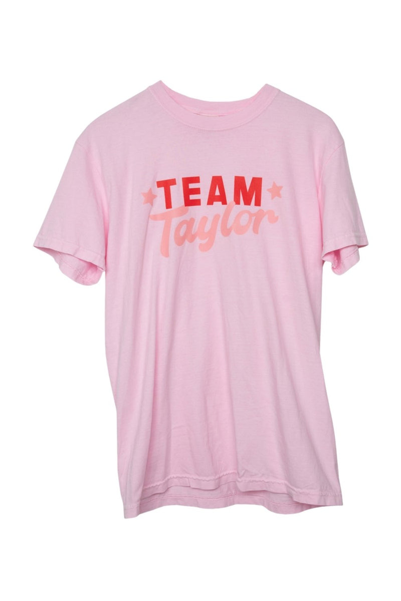 The Katydid Team Taylor T-Shirt is a pink women’s tee featuring bold TEAM Taylor text in red and pink. This comfy graphic shirt is perfect for fans and ideal for everyday wear.