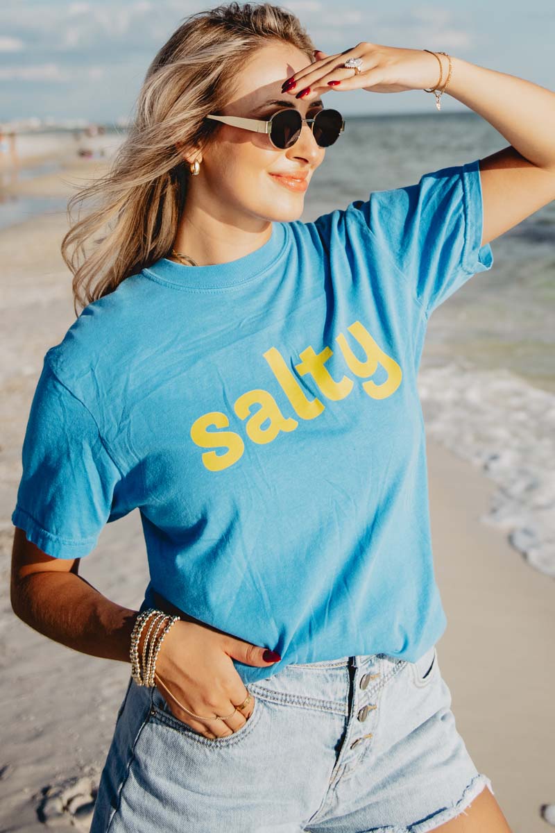 A woman wearing a salty tshirt on the beach